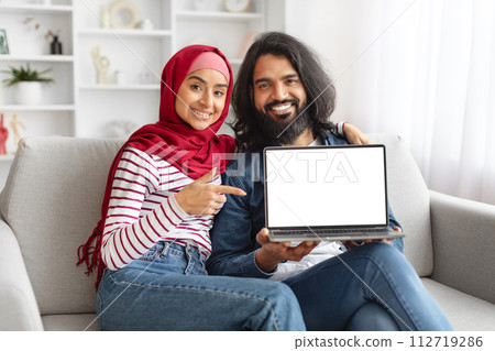 Great Website. Cheerful Muslim Spouses Demonstrating Blank Laptop Screen At Home Great Website. Cheerful Muslim Spouses Demonstrating Blank Laptop Screen At Home 112719286