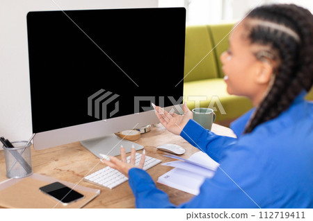Confused black female student looking at blank computer screen 112719411