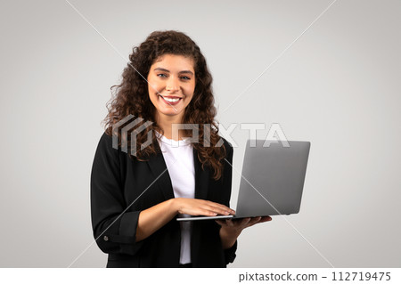 Smiling businesswoman working on laptop Smiling businesswoman working on laptop 112719475