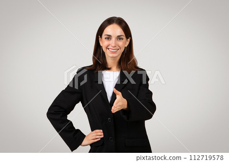 Approachable and professional young businesswoman with long hair wearing a black suit 112719578