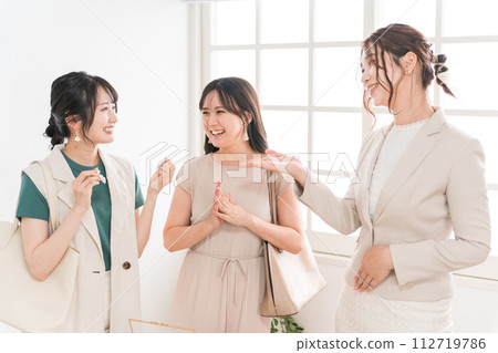 Female friends/colleagues and sales staff choosing earrings at a jewelry store (department store/branded items) 112719786