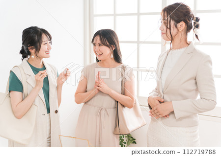Female friends/colleagues and sales staff choosing earrings at a jewelry store (department store/branded items) Female friends/colleagues and sales staff choosing earrings at a jewelry store (department store/branded items) 112719788