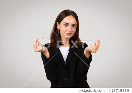 Professional young woman with a neutral expression presenting an open-handed gesture as if holding Professional young woman with a neutral expression presenting an open-handed gesture as if holding 112719819