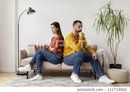 Couple Sitting Back To Back To Each Other On Couch At Home 112719882