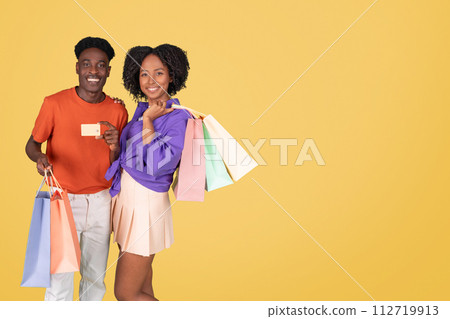 An exuberant young man in an orange shirt and a delighted young woman 112719913