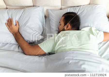 Top view of peaceful black man sleeping in comfy bed Top view of peaceful black man sleeping in comfy bed 112719924