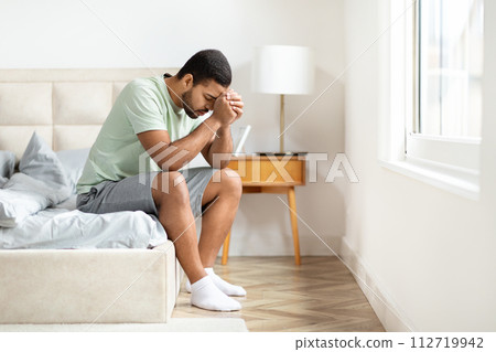Unhappy african american guy suffering from loneliness, bedroom interior 112719942