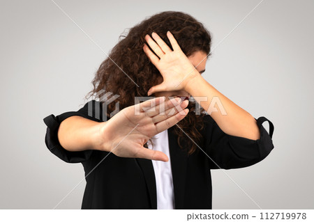 Businesswoman making stop gesture with her hand and covering face Businesswoman making stop gesture with her hand and covering face 112719978