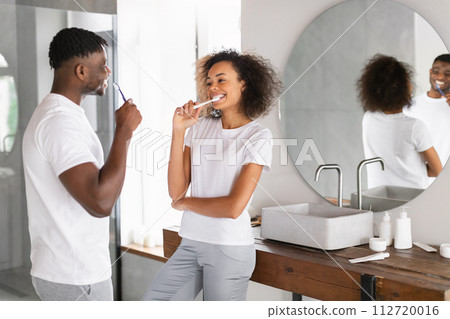 Black couple embraces dental care in morning brushing teeth indoor 112720016