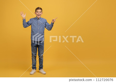 Happy Excited Teen Boy Pointing Aside At Copy Space With Finger 112720076