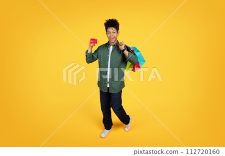 Cool black guy enjoying unlimited shopping, full length 112720160