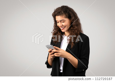 Smiling businesswoman looking at smartphone Smiling businesswoman looking at smartphone 112720187