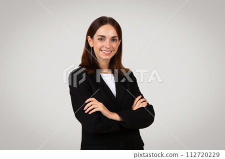 Confident young businesswoman with a pleasant smile, wearing a black suit and white shirt Confident young businesswoman with a pleasant smile, wearing a black suit and white shirt 112720229