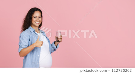 Positive pregnant woman holding glass of water Positive pregnant woman holding glass of water 112720262