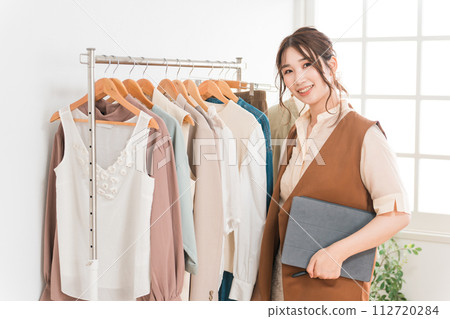 A female clerk using a tablet at an apparel shop (inventory management/product management) 112720284