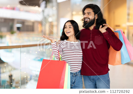 Excited young hindu couple enjoying season sale shopping together 112720292