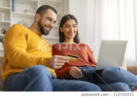 Easy Payments. Happy Young Couple With Laptop And Credit Card At Home 112720331
