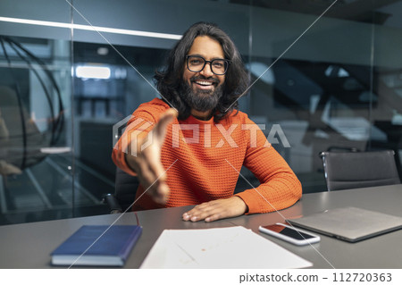 Friendly bearded young indian businessman outstretching hand Friendly bearded young indian businessman outstretching hand 112720363