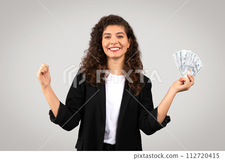 Happy businesswoman with cash celebrating success Happy businesswoman with cash celebrating success 112720415
