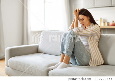 Woman In Depression. Sad Young Female Sitting On Couch At Home Woman In Depression. Sad Young Female Sitting On Couch At Home 112720433