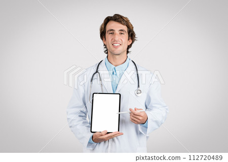Cheerful male doctor presenting blank tablet screen Cheerful male doctor presenting blank tablet screen 112720489