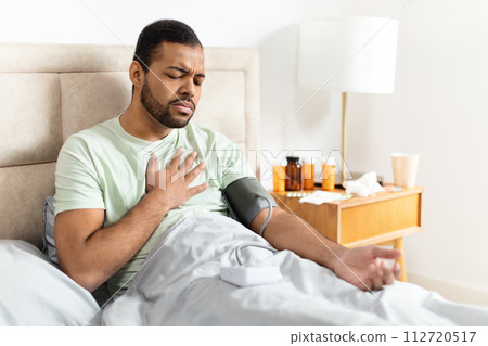 Unhealthy african american man doing morning checkup after waking up 112720517
