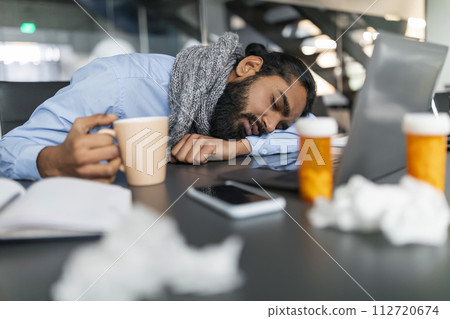 Exhausted Sick Indian Businessman Asleep at Desk at Office Exhausted Sick Indian Businessman Asleep at Desk at Office 112720674