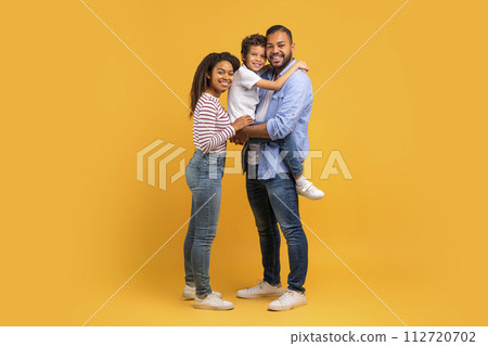 Happy black family in loving embrace, with the son in fathers arms 112720702