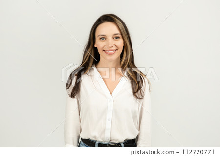A friendly young woman with long brunette hair, wearing a crisp white blouse and blue jeans A friendly young woman with long brunette hair, wearing a crisp white blouse and blue jeans 112720771