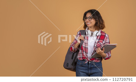 Pretty young middle eastern woman student posing on beige background Pretty young middle eastern woman student posing on beige background 112720791