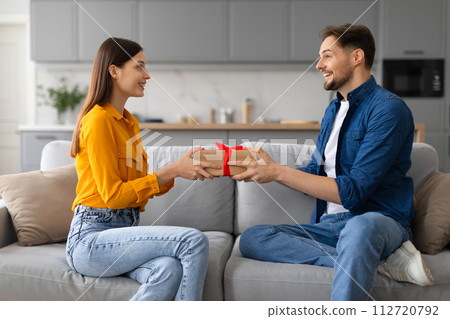 Happy spouses exchanging gifts, woman receiving present 112720792