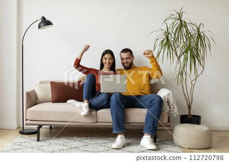 Happy Excited Young Couple Celebrating Success With Laptop At Home 112720798