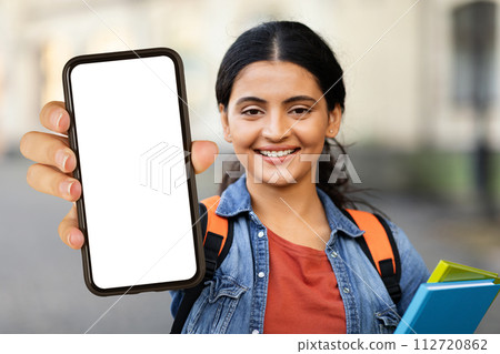Smiling indian woman student showing phone with white screen 112720862