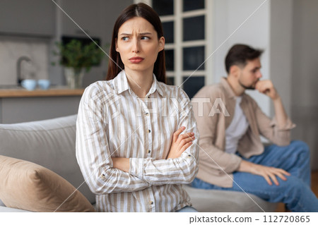 Annoyed woman with arms crossed, man in background Annoyed woman with arms crossed, man in background 112720865