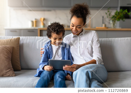 Black mother and son enjoying time together with tablet Black mother and son enjoying time together with tablet 112720869