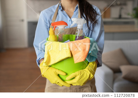Close-up of cleaning supplies in bucket held by woman 112720878