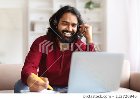 Indian man studying from home, watching online lesson 112720946