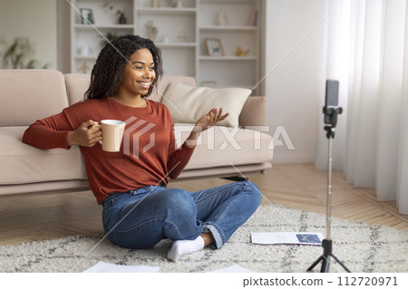 Happy young black woman recording a vlog on her smartphone 112720971