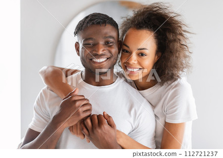 happy young black couple dressed in t-shirts embraces in bathroom happy young black couple dressed in t-shirts embraces in bathroom 112721237