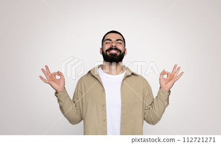 A man with a full beard and a beaming smile makes the 'okay' sign with both hands A man with a full beard and a beaming smile makes the 'okay' sign with both hands 112721271