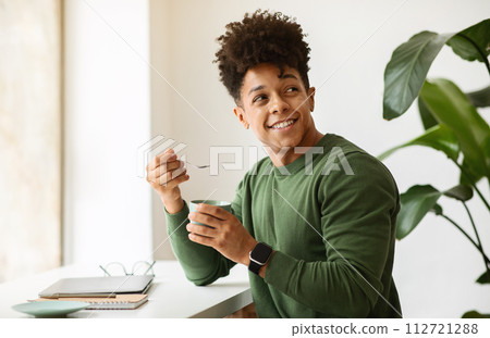 Stylish african american guy drinking cappuccino while working at cafe Stylish african american guy drinking cappuccino while working at cafe 112721288