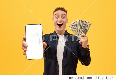 Emotional guy with money cash and smartphone on yellow 112721298