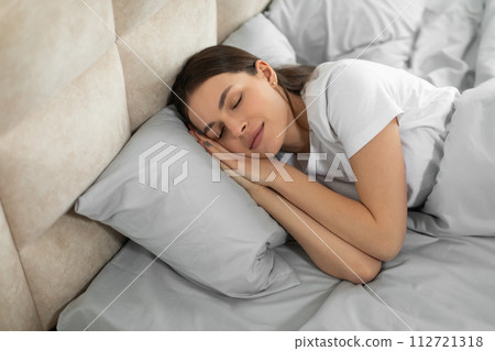 Peaceful european woman enjoying restful sleep Peaceful european woman enjoying restful sleep 112721318
