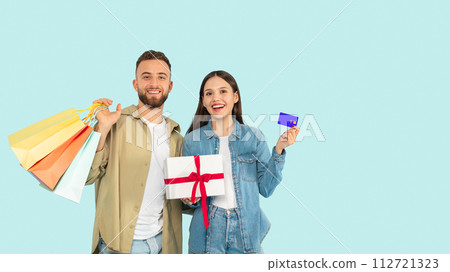 Couple With Shopper Bags Holding Gift Showing Credit Card, Studio Couple With Shopper Bags Holding Gift Showing Credit Card, Studio 112721323