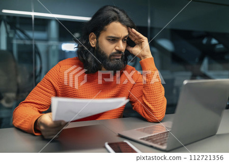 Stressed indian man entrepreneur sitting at dark office Stressed indian man entrepreneur sitting at dark office 112721356