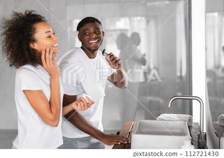 Loving black millennial spouses sharing morning routine in bathroom interior Loving black millennial spouses sharing morning routine in bathroom interior 112721430