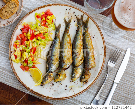 Grilled sardines served with fresh vegetable salad 112721442