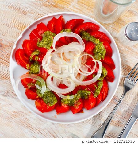 Colorful tomato salad with onions and basil pesto 112721539