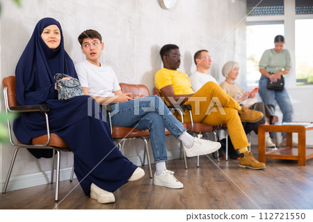 Young arab woman and teen boy waiting in line at reception Young arab woman and teen boy waiting in line at reception 112721550