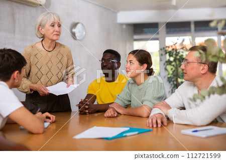 Elderly manager holds round table meetings for employees of different nationalities Elderly manager holds round table meetings for employees of different nationalities 112721599